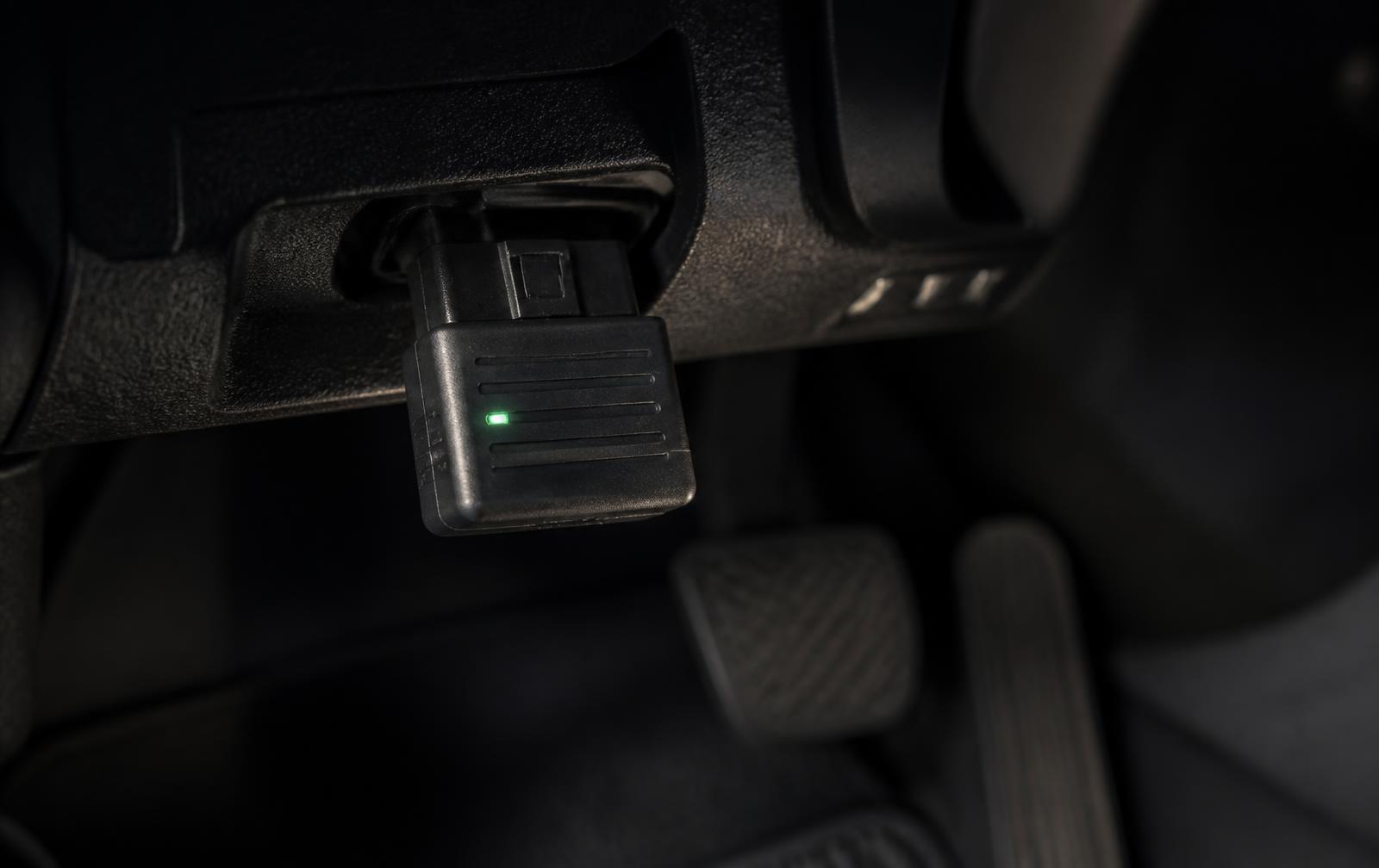 OBD-II adapter plugged in under a car dashboard